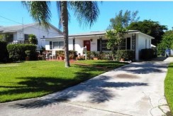 Driveway leads to gated waterfront rear yard.