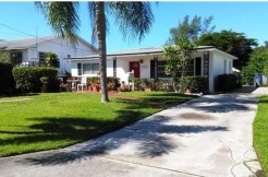 Driveway leads to gated waterfront rear yard.