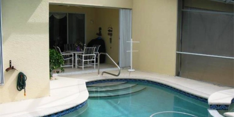 View from inside screened lanai of pool/spa and under-roof area