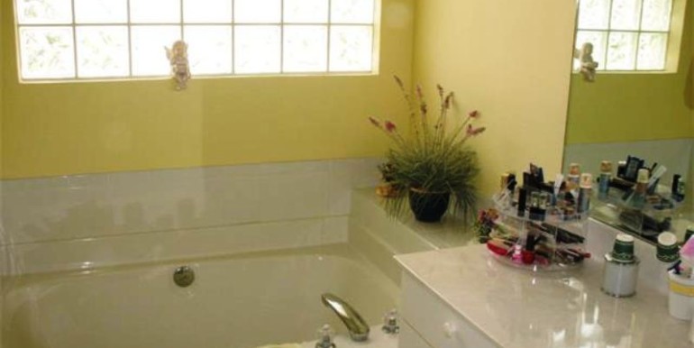 Bright Master Bath has solid-surface counters, dual sinks and so